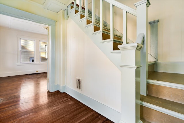 staircase with wood finished floors, visible vents, and baseboards