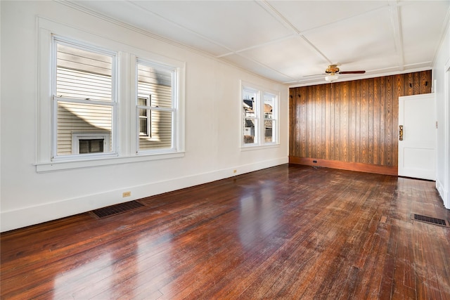 empty room featuring visible vents, baseboards, dark wood-style floors, and a ceiling fan