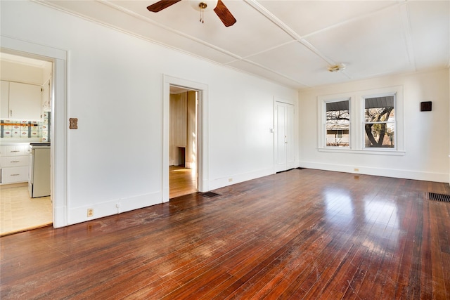 spare room with visible vents, a ceiling fan, baseboards, and hardwood / wood-style flooring