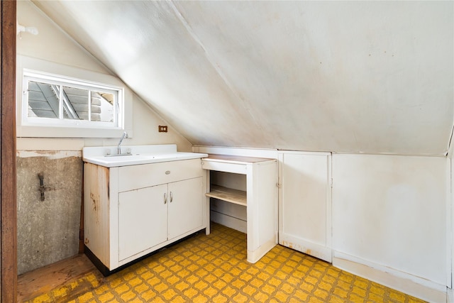 additional living space featuring vaulted ceiling, light floors, and a sink