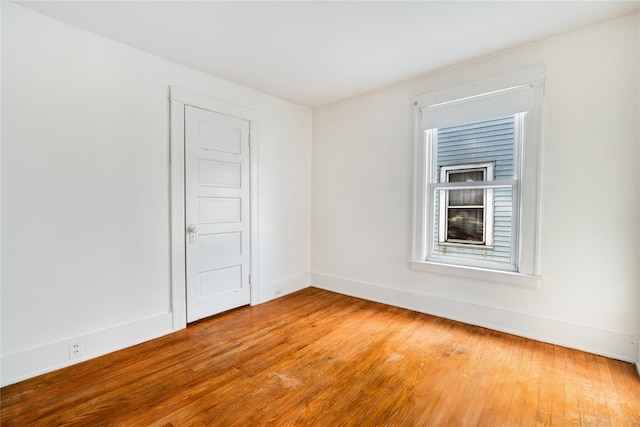 empty room with baseboards and light wood finished floors