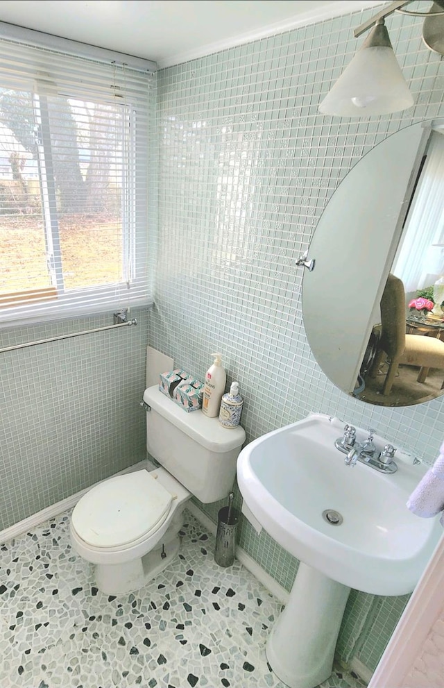 bathroom with toilet, tile walls, and tile patterned flooring