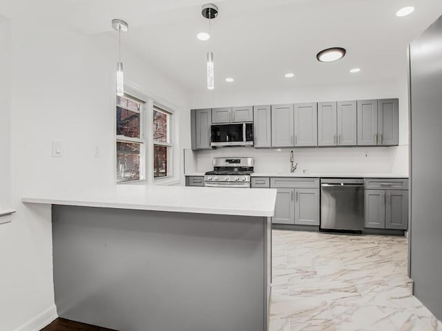 kitchen featuring gray cabinets, a sink, light countertops, appliances with stainless steel finishes, and marble finish floor