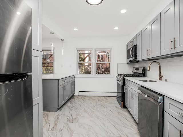 kitchen with gray cabinetry, light countertops, appliances with stainless steel finishes, marble finish floor, and a sink