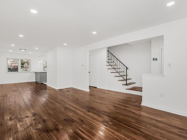 unfurnished living room with stairway, recessed lighting, wood finished floors, and baseboards