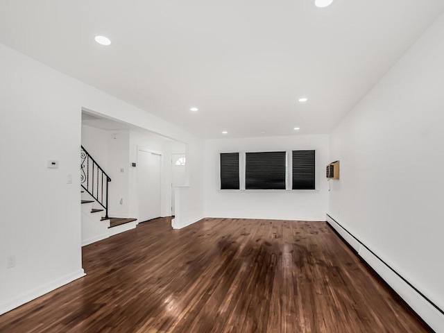 unfurnished living room with recessed lighting, a baseboard radiator, wood finished floors, and stairway