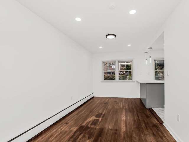 unfurnished room featuring recessed lighting, wood finished floors, and a baseboard radiator