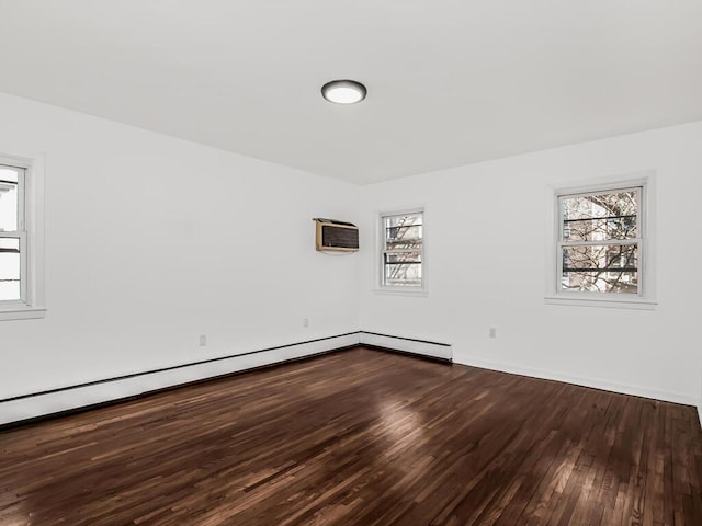 spare room featuring an AC wall unit and wood finished floors