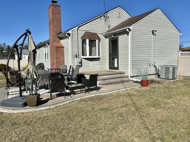 rear view of property featuring a yard, central AC unit, fence, and a chimney