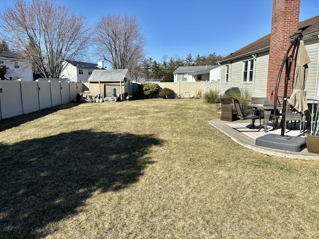 view of yard with an outbuilding, a fenced backyard, and a residential view