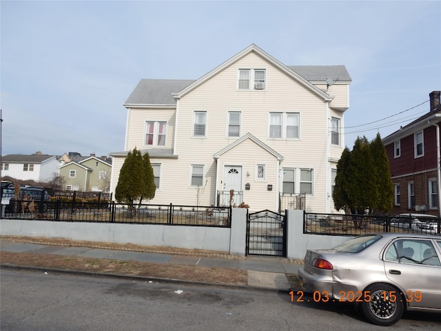 townhome / multi-family property featuring a fenced front yard and a gate