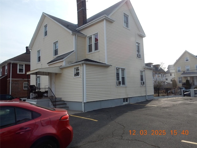 view of side of property with a residential view and a chimney