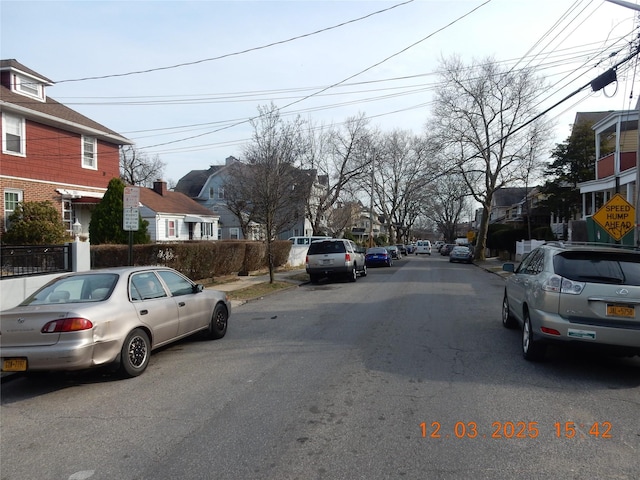 view of road featuring sidewalks, traffic signs, and a residential view