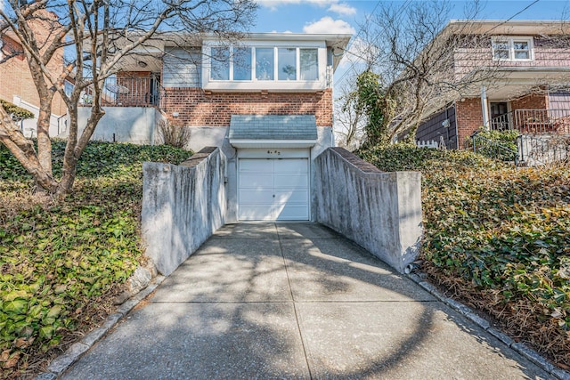 view of front facade with brick siding, concrete driveway, and an attached garage