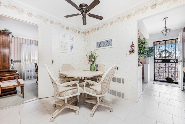 dining space with baseboards, wallpapered walls, radiator heating unit, ceiling fan, and ornamental molding