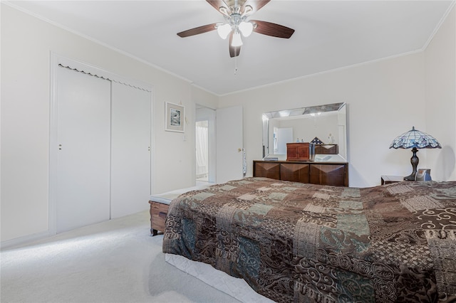 bedroom featuring a closet, a ceiling fan, crown molding, and carpet