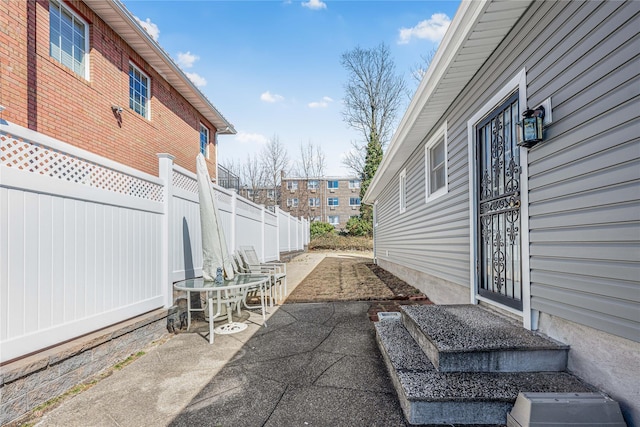 view of patio / terrace featuring fence and a residential view