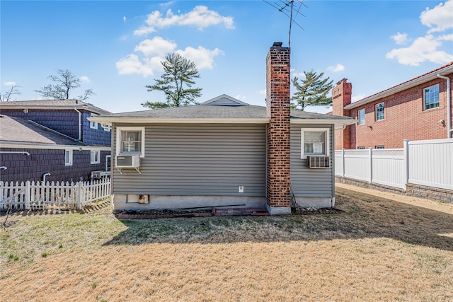 back of house with a lawn, cooling unit, a chimney, and fence