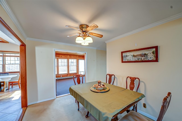 dining area with ceiling fan, baseboards, light carpet, and ornamental molding