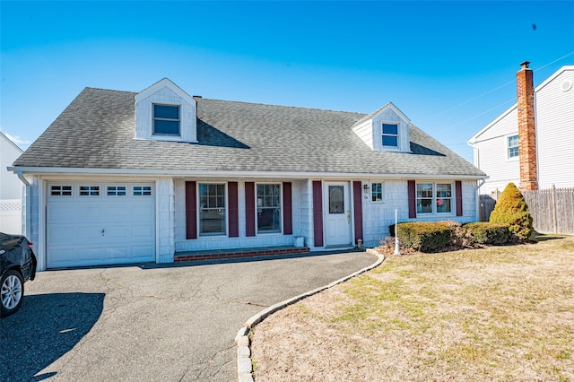 cape cod-style house with aphalt driveway, fence, a garage, and a shingled roof