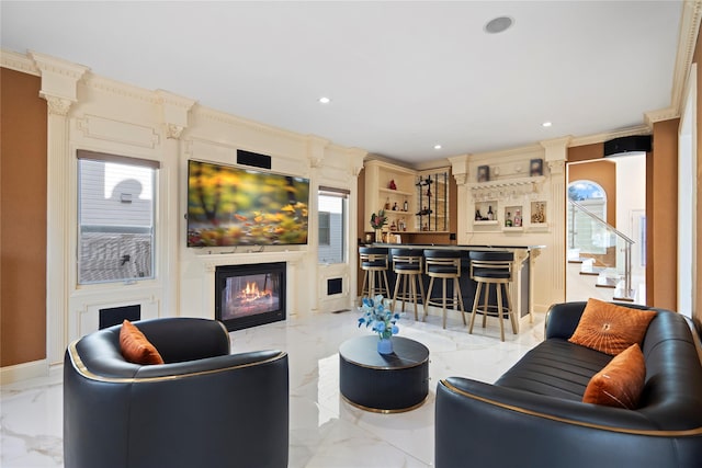 living room featuring crown molding, a dry bar, recessed lighting, a glass covered fireplace, and marble finish floor