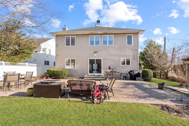 back of house featuring a patio, a lawn, a chimney, and fence