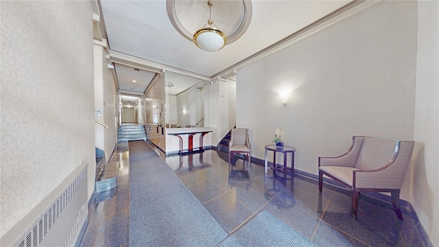 interior space with radiator heating unit, granite finish floor, crown molding, baseboards, and stairs