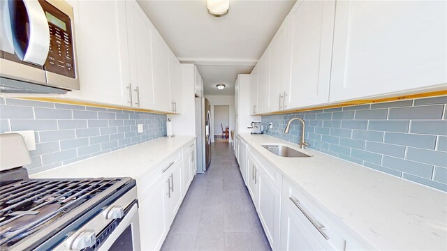 9425 Shore Rd Unit 6C, Brooklyn, NY 11209 - kitchen with a sink, stainless steel appliances, tasteful backsplash, and white cabinetry