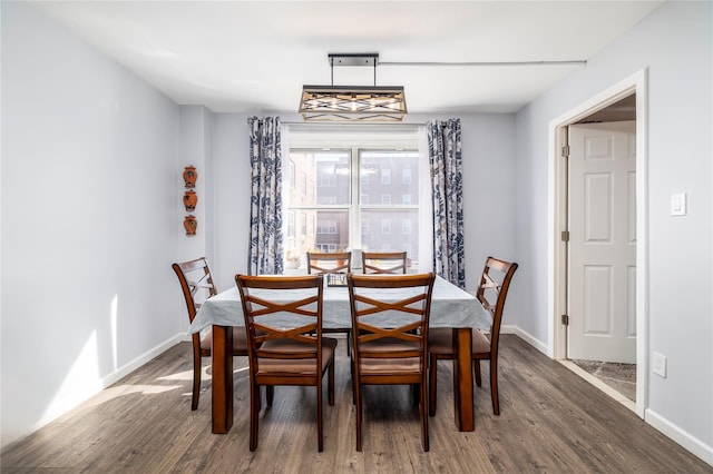 dining space featuring wood finished floors and baseboards