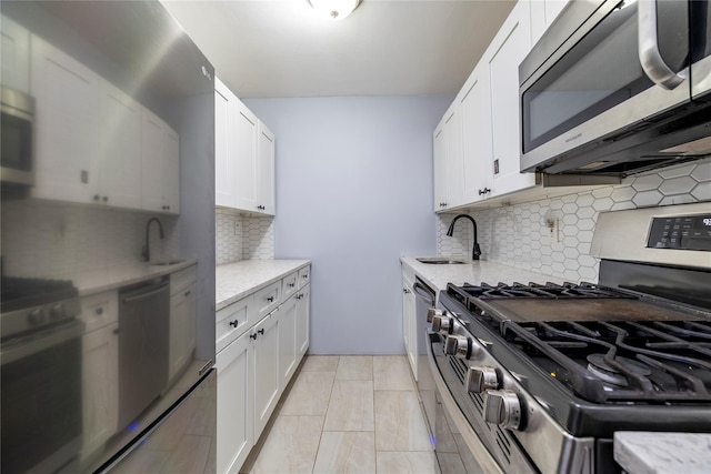 kitchen with a sink, appliances with stainless steel finishes, and white cabinetry