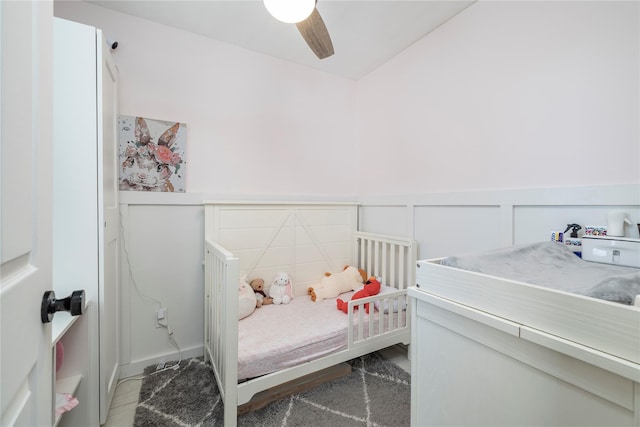 bedroom with wainscoting and a ceiling fan