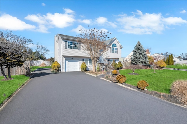 view of front facade with fence, aphalt driveway, stairs, a front yard, and a garage