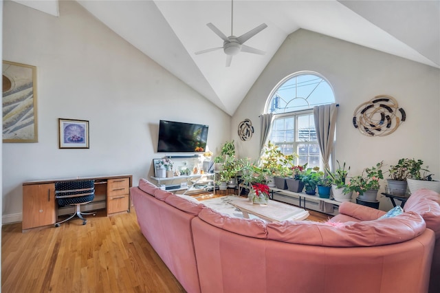 living area featuring high vaulted ceiling, light wood-style floors, and a ceiling fan