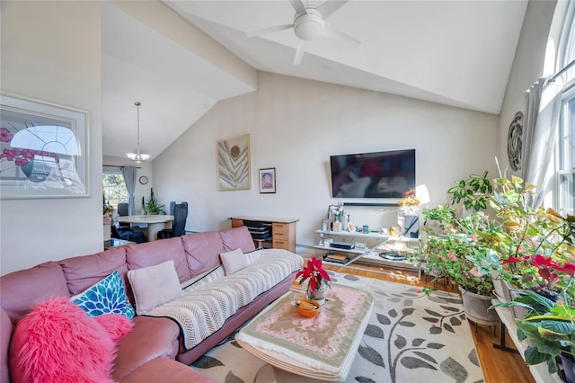 living room featuring high vaulted ceiling, wood finished floors, and ceiling fan with notable chandelier