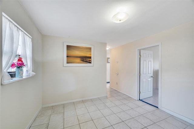 spare room with light tile patterned floors and baseboards