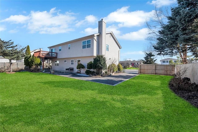 back of house with a patio area, fence, a lawn, and a chimney