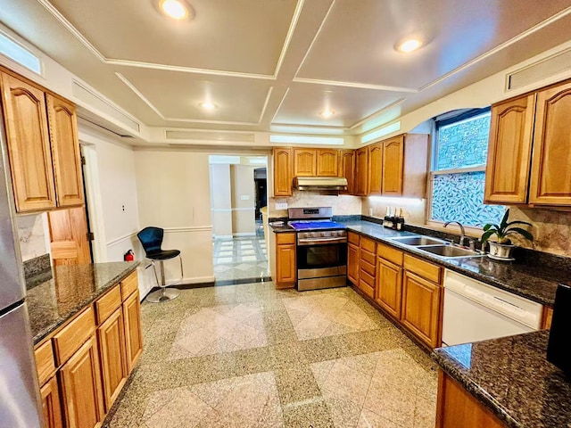 kitchen featuring stainless steel range with gas cooktop, granite finish floor, a sink, under cabinet range hood, and dishwasher