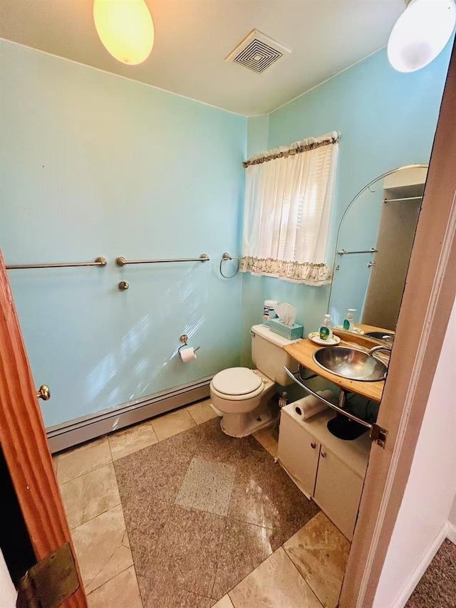 bathroom featuring vanity, visible vents, tile patterned flooring, a baseboard heating unit, and toilet