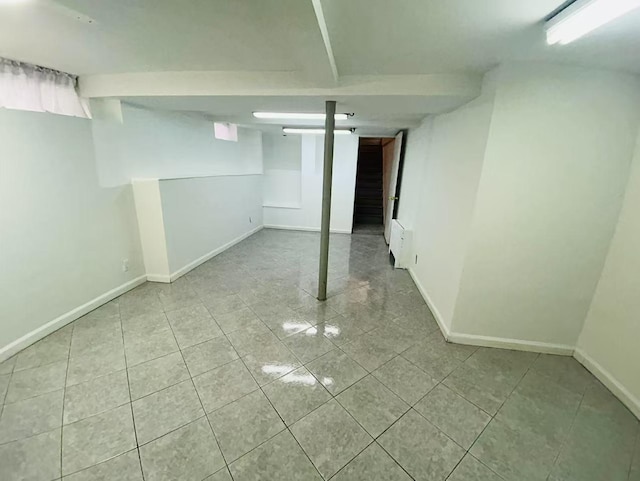 finished below grade area featuring tile patterned floors and baseboards