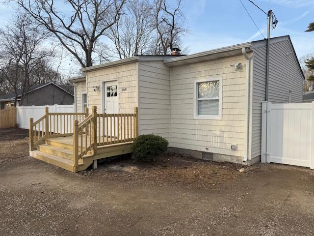 view of front of home featuring fence and crawl space