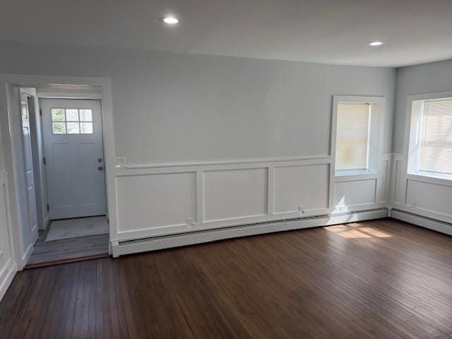 interior space featuring dark wood-type flooring, a wainscoted wall, recessed lighting, a decorative wall, and a baseboard radiator