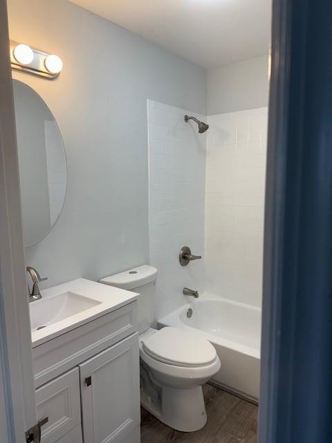 bathroom featuring toilet, vanity, shower / bathing tub combination, and wood finished floors