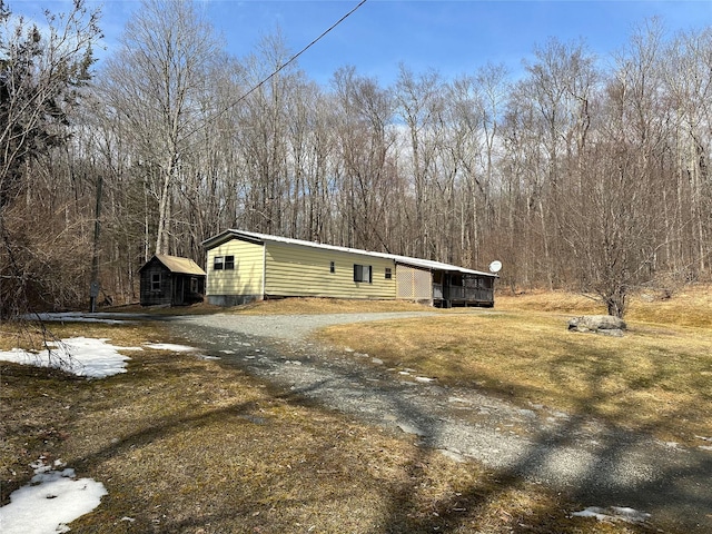 view of side of property featuring driveway and an outdoor structure