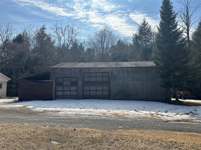 snow covered garage featuring a detached garage