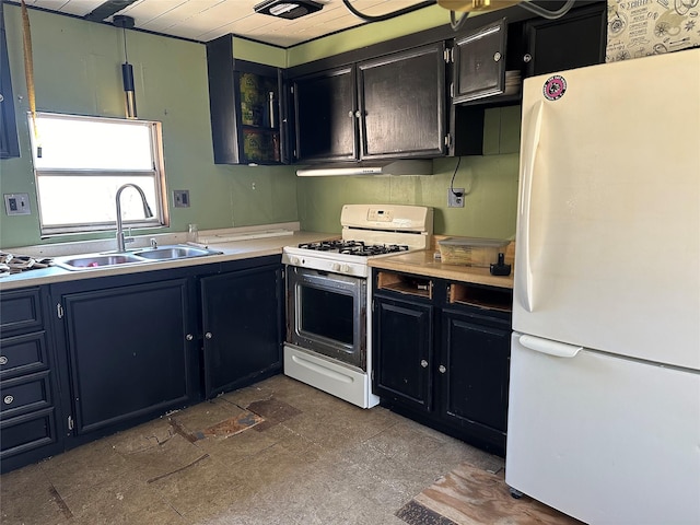 kitchen featuring a sink, white appliances, dark cabinets, and light countertops