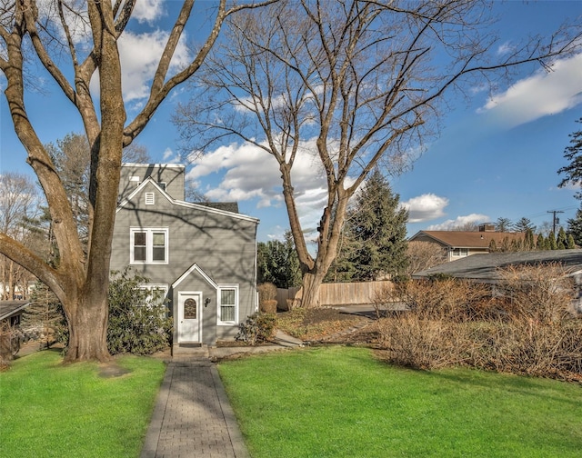 view of front of house with a front yard and fence