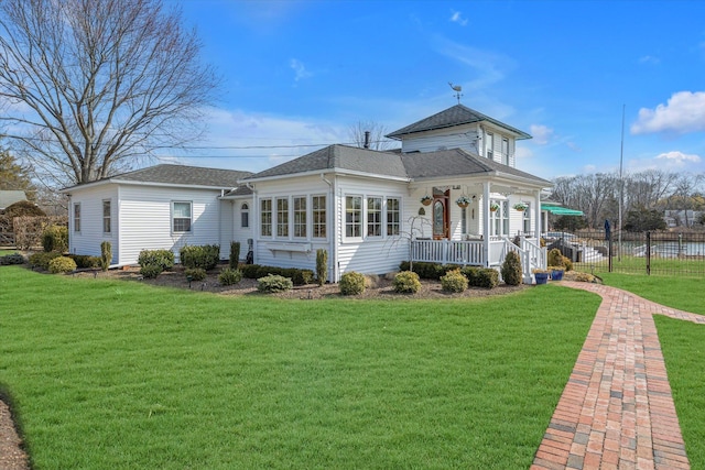 back of property featuring fence, a lawn, and roof with shingles