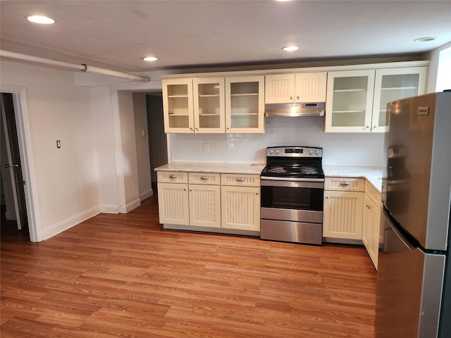 48 S St, Goshen, NY 10924 - kitchen with stainless steel appliances, under cabinet range hood, light countertops, tasteful backsplash, and light wood-type flooring