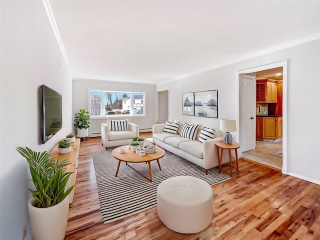 living room with crown molding, light wood-style floors, baseboards, and baseboard heating