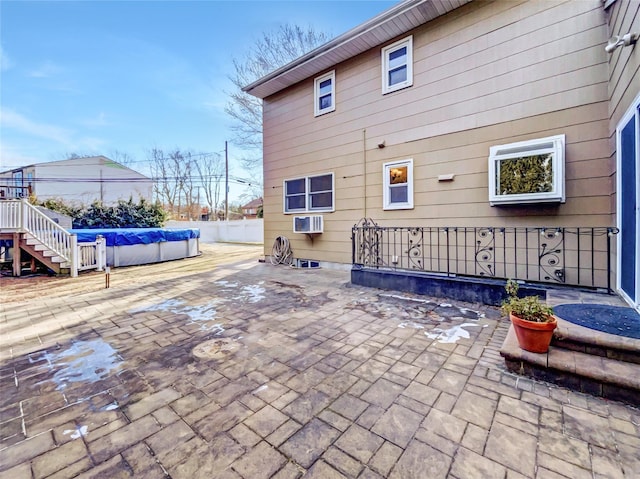 1 Charter Ln, Smithtown, NY 11787 - rear view of house with a patio, a wall unit AC, fence, and a fenced in pool
